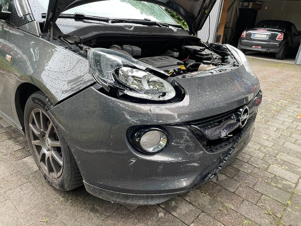 Opel Adam mit geöffneter Motorhaube nach Unfall – konkretes Beispiel aus der gemeinsamen Schadenabwicklung.